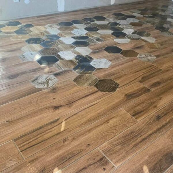 Intégration de carreaux hexagonaux décoratifs dans un carrelage imitation bois